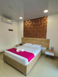 a bedroom with a large bed with a red blanket at HOTEL VIOLETTA Cereté in Cereté
