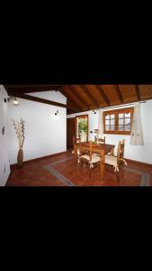 a dining room with a wooden table and benches at Casa Matilde in Hermigua