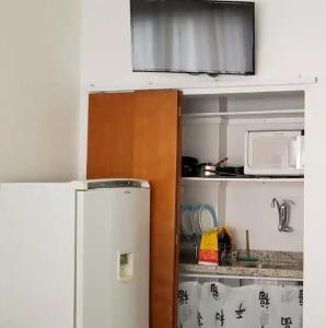una pequeña cocina con nevera y microondas en Loft Aconchegante Centro Niterói / RJ Inter 300Mb en Niterói
