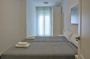 1 dormitorio con 2 camas y toallas. en Exclusivo Apartamento en el Centro de Sevilla, en Sevilla