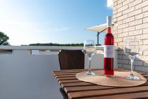 butelka wina na stole z dwoma kieliszkami w obiekcie Apartment Eros w mieście Šišan