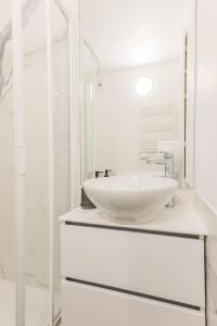 a white bathroom with a sink and a mirror at Bel Appartement Juan les Pins in Antibes