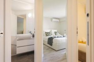 a white bedroom with a bed and a sink at Bel Appartement Juan les Pins in Antibes