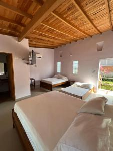 1 dormitorio grande con 2 camas y ventana en Hotel Parador del Gitano, en Doradal