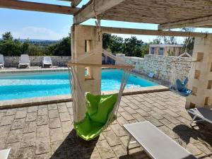 patio con amaca e piscina di Dimora Bianca a Cisternino