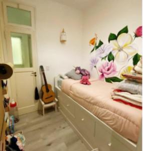 ein Schlafzimmer mit einem Bett mit Blumen an der Wand in der Unterkunft Departamento Güemes in Mar del Plata