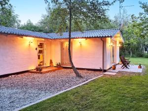una pequeña casa blanca con un árbol en el patio en Holiday home Hurup Thy XVIII, en Sønder Ydby