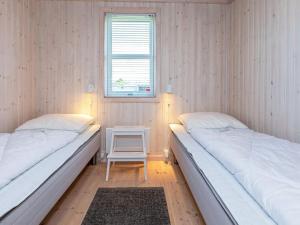 duas camas num quarto com uma mesa e uma janela em Holiday home Løgstør XXIV em Løgsted