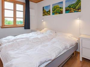 a large white bed in a room with a window at Holiday home Aars II in Års