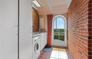 a kitchen with a brick wall and a washing machine at 3 Bedroom Amazing Home In Ringkbing in Ringkøbing