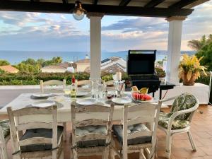 a table with a laptop on top of a patio at Mikaela Beach House Estepona Marbella Malaga in Estepona