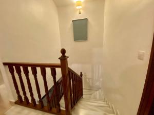 una escalera con barandilla de madera y un tablero de madera en la pared en Mikaela Beach House Estepona Marbella Malaga, en Estepona