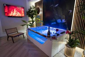 a fish tank in a living room with a bench at Aparthotel ZATOR Retro 66 jacuzzi in Zator