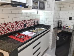 a kitchen with a stove and a sink at Apartamento na Barra da Tijuca in Rio de Janeiro