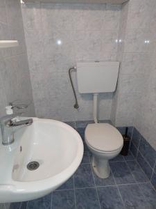 bagno con servizi igienici bianchi e lavandino di Soufis house a Igoumenítsa
