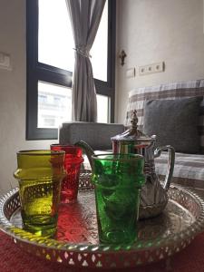 szklana taca z czterema różnymi kolorowymi wazami na stole w obiekcie La Gironde - Sweet Home - Casablanca w mieście Casablanca