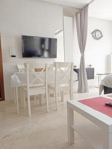 une salle à manger blanche avec une table et des chaises dans l'établissement La Gironde - Sweet Home - Casablanca, à Casablanca