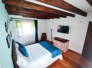 a bedroom with a bed and a dresser and a television at Casa El Retiro - Villa de Leyva in Villa de Leyva