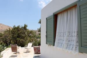 a group of chairs sitting on a patio with a window at Aegean traditional home in Athens Riviera in Sounio