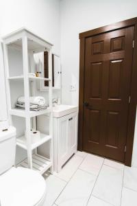 a bathroom with a white toilet and a brown door at Flower Apartments in Los Angeles