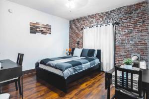 a bedroom with a bed and a brick wall at Flower Apartments in Los Angeles