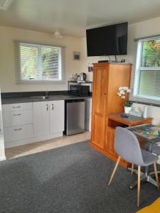 cocina con TV en la parte superior de un armario de madera en Sunset Accommodation, en Westport