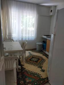 una pequeña cocina con mesa y alfombra en el suelo en Rafet Aksoy, en Yalova