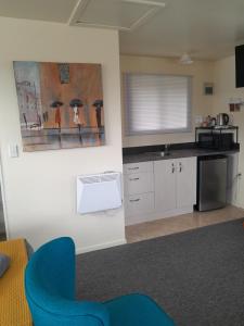 uma cozinha com uma cadeira azul num quarto em Sunset Accommodation em Westport