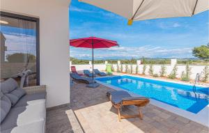 einen Pool mit einem roten Sonnenschirm und Stühlen in der Unterkunft Pet Friendly Home In Sibenik With Heated Swimming Pool in Šibenik