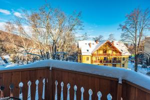 una recinzione di fronte a una casa coperta di neve di HELLO Apartamenty - Jelenka blisko centrum a Karpacz
