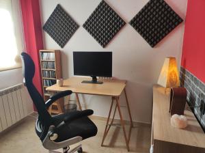 a computer desk with a chair and a computer monitor at Entre la Alhambra y Sierra Nevada in Cenes de la Vega +9 photos