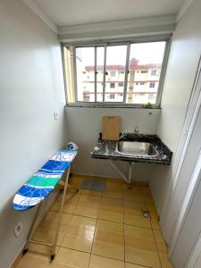 uma pequena casa de banho com um lavatório e uma janela em Excelente Apartamento - Localização ótima em Macapá
