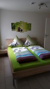 1 cama con edredón y almohadas verdes en BeHappy, en Rust