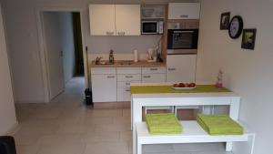 Una cocina con una mesa con un bol de fruta encima. en BeHappy, en Rust 10 fotos más
