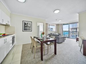 a kitchen and living room with a table and chairs at Quest Breakfast Creek in Brisbane