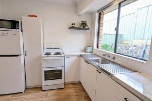 a kitchen with a white refrigerator and a sink at Boutique Home Close to Town and Nature in Bunbury