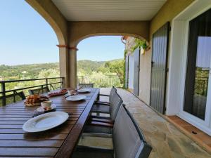 stół na ganku z widokiem na góry w obiekcie Le Jardin des Olives w mieście Caunes-Minervois