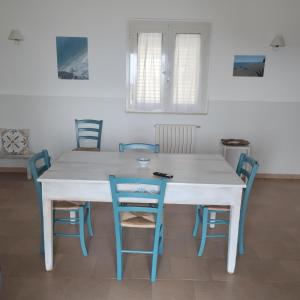 馬蒂納塔的住宿－Diomede Holiday Home，客房内的白色桌子和蓝色椅子