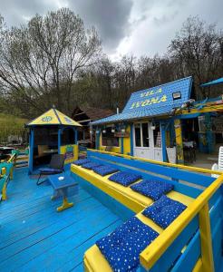 una terraza azul y amarilla con asientos azules en un parque infantil en Vila Ivona en Čačak