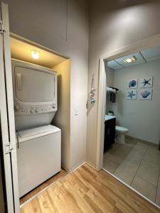 a bathroom with a washer and dryer and a toilet at Luxéry Stay Chicago - Across from McCormick Place & Wintrust Arena in Chicago