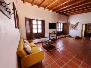 a living room with a yellow couch and a table at Casa Entrevez in Valle de Guadalupe