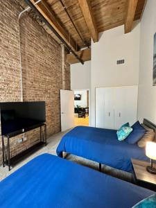 シカゴにあるLuxéry Stay Chicago - Themed Units! Close to Downtown, McCormick Place & Wintrust Arenaのベッド2台と薄型テレビ付きのベッドルーム