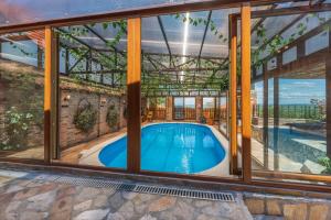 uma piscina interior numa casa com janelas de vidro em Etno Vila Kula em Malo Središte