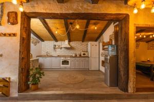 uma cozinha com electrodomésticos brancos e um tecto de madeira em Etno Vila Kula em Malo Središte