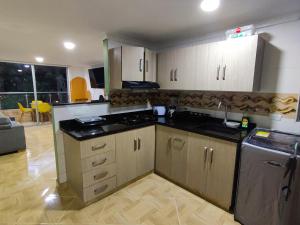 a kitchen with white cabinets and black counter tops at Apartamento en Laureles con Excelente Ubicación in Medellín
