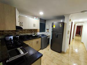 a kitchen with a black refrigerator in a room at Apartamento en Laureles con Excelente Ubicación in Medellín