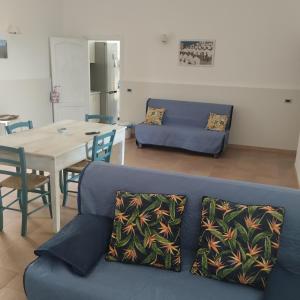 馬蒂納塔的住宿－Diomede Holiday Home，客厅配有蓝色的沙发和桌子