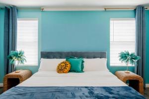 een slaapkamer met een groot bed met blauwe muren bij Backyard Pool Oasis @ Tropicale Blue in Coachella