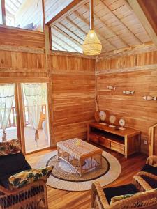 a living room with wooden walls and a table at villa gilimakyah in Gili Air