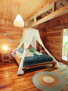 a bedroom with a bed with a mosquito net at villa gilimakyah in Gili Air